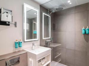 阿姆斯特丹阿姆斯特丹市诺富特酒店的白色的浴室设有水槽和淋浴。