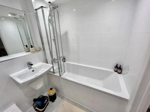 博勒姆伍德2-bed flat in central Borehamwood location的白色的浴室设有水槽和淋浴。