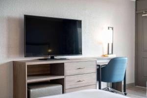 可可比奇可可海滩海滨拉昆塔套房酒店的客房设有书桌、电视和椅子