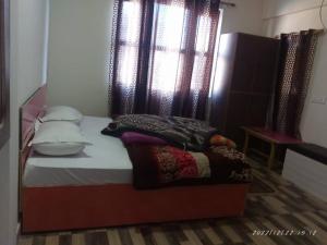 乔斯希马特Hotel Rocks and pine Auli的一间卧室配有一张带窗户和枕头的床