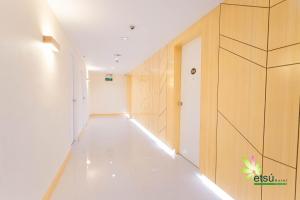 独鲁万Etsu Hotel的白色地板和木墙的走廊