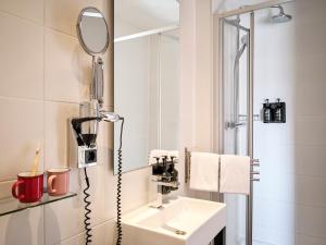 阿姆斯特丹Max Brown Hotel Museum Square, part of Sircle Collection的一间带水槽和镜子的浴室