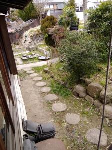 高槻市Japanese old house的一座花园,花园内有一条岩石小径和一座房子