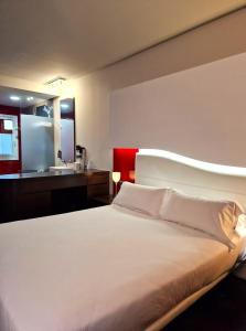 维戈Hotel Maroa Vigo的一间带白色大床的卧室和一间浴室