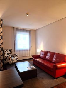 维戈Hotel Maroa Vigo的客厅配有红色的沙发和椅子