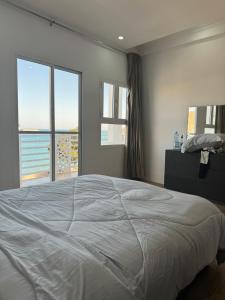 马斯喀特Muttrah Souq and Sea View的一间卧室设有一张大床和两个窗户。