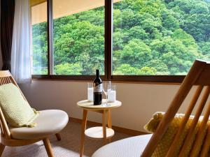鹿角汤濑酒店的坐在窗边桌子上的一瓶葡萄酒