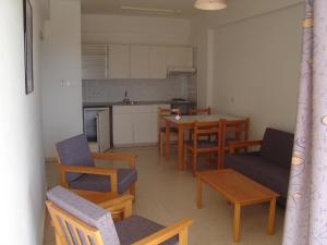 普罗塔拉斯Pola Costa Beach Hotel Apts - Adults Only的一间带桌椅的客厅和一间厨房
