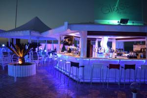 普罗塔拉斯Pola Costa Beach Hotel Apts - Adults Only的酒吧,晚上在餐厅里设有酒吧凳子