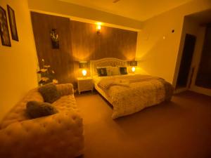 伊斯兰堡Viceroy Royal Hotel Apartment Islamabad的一间卧室配有一张大床和一张沙发