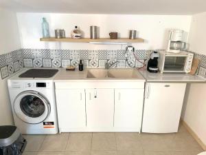 德尔塔Studio avec jardin clos et wifi a Durtal的厨房配有水槽和洗衣机