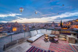 格雷梅泰拉凯芙酒店的阳台配有沙发、桌子和热气球