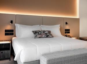 阿纳维索斯Vincci EverEden的卧室配有带白色枕头的大床