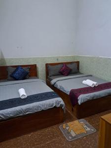 贡布Guesthouse Chamroeun Mongkul的一间设有两张床铺和毛巾的房间