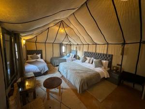 梅尔祖卡Merzouga Stars Luxury Camp的一间帐篷内带两张床的卧室