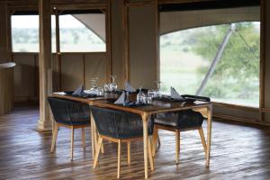 塞伦盖蒂Anantya Serengeti的餐桌、椅子和桌子及玻璃杯