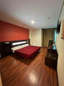 马德里LA CANTUEÑA的一间卧室设有一张大床和红色的墙壁