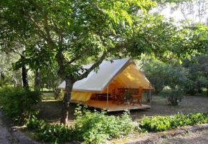 萨米Camping Karavomilos的树下带桌子的黄色帐篷