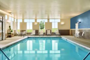 丹佛凯悦丹佛机场酒店的游泳池位于酒店客房内,配有桌椅
