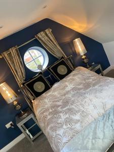 奥尔斯特Elegant home near Stratford upon avon的一间卧室配有一张带两盏灯的床和一扇窗户。