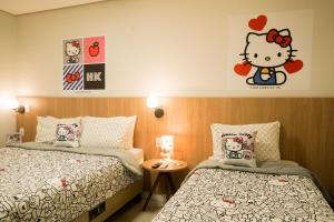 瓜伊拉Trento Hotel Guaíra by Unna的卧室配有两张床,墙上挂着一个小猫的贴纸。