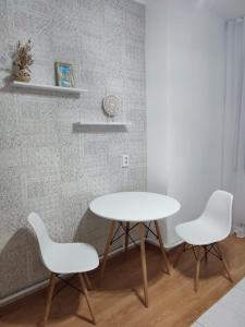 巴甫洛达尔Апартаменты Жаяу Мусы 7А的一张桌子和两张白色椅子