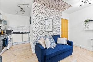 迪斯伯里Lovely Yorkshire Duplex - Sleeps 6 - Netflix的客厅设有蓝色沙发,厨房设有