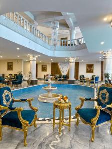 Al HumaizahVista Haql Hotel的大堂设有喷泉、椅子和桌子