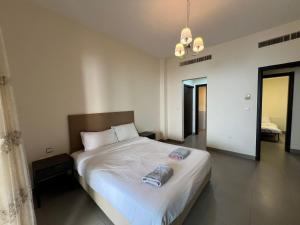 索瓦马E03 Samarah Resort Apartments的卧室配有一张带吊灯的大型白色床。