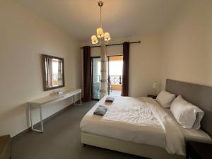 索瓦马E03 Samarah Resort Apartments的一间卧室设有一张大床和一个窗户。