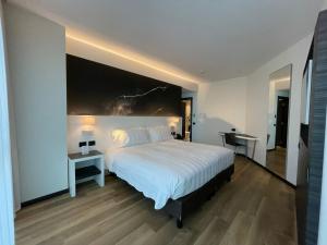 贝加莫Life Hotel的一间卧室配有一张大床、两张桌子和两盏灯。