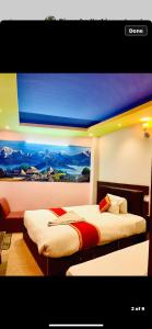 加德满都Global hotel的卧室内的两张床,墙上有绘画作品
