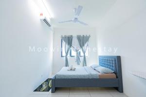 北赖Cozy&Comfy Suite Room Perai的卧室配有蓝色的床,位于白色的墙壁上