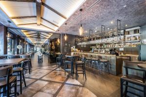 科马尔诺HOTEL EUROPA的一间带桌椅的餐厅和一间酒吧