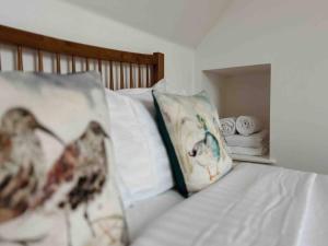 卡博斯特One Bedroom Apartment - Carbost - Skye的床上配有枕头和毛巾