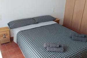 卡耐特蒂贝兰格Acogedor apartamento en la playa de Canet的一间卧室配有一张带黑白色棉被的床