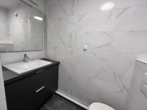 塞纳河畔伊夫里HOTEL LES PORTES DE PARIS的白色的浴室设有水槽和卫生间。