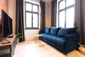 卢巴瓦新城Central LOFT的客厅设有蓝色的沙发,配有窗户