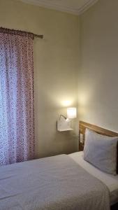 阿尔马达Margarida Guest House的一间卧室配有一张带窗帘和灯的床