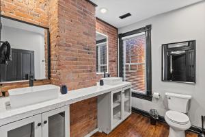 华盛顿Spacious, Historic Logan Circle Rowhouse的一间带两个水槽和砖墙的浴室