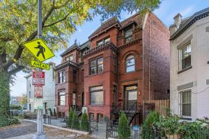 华盛顿Spacious, Historic Logan Circle Rowhouse的砖楼前的街道标志