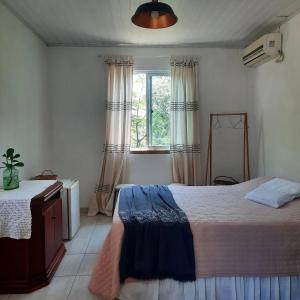 塞尔苏拉穆斯州长镇Sitio do Ma Vio的一间卧室设有一张大床和一个窗户。