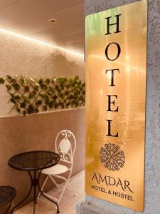 埃拉特Amdar Hostel的酒店标志和桌椅