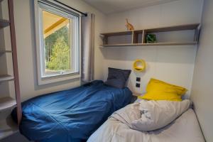 沃洛格河畔格朗热Flower Camping La Sténiole的一间卧室设有一张床和一个窗口