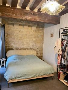 凯恩Sublime appartement typique hypercentre Caen的一间卧室设有一张床和砖墙