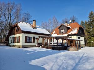 奥斯特拉维采河畔弗里德兰特Chaloupka u řeky的前面的地面上积雪的房子