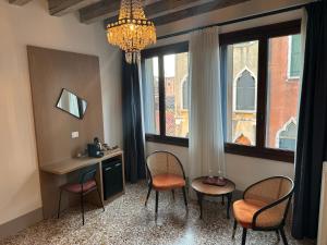 威尼斯TRA SAN MARCO E RIALTO的一间带椅子和书桌的房间以及吊灯