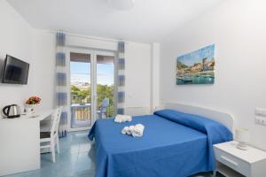 伊斯基亚B&B La Vigna Rooms - Ischia Ponte的一间卧室设有蓝色的床和窗户。