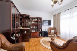 丰沙尔Casa Monte by GALMI的客厅配有皮革家具和吊灯。