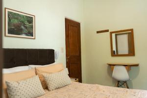 蒙得维的亚Coliving Med by Hotel Mediterràneo的一间卧室配有带枕头和镜子的床